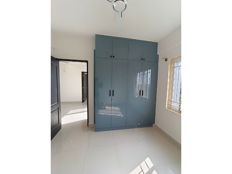 Glossy Finish Four Door Wardrobe With Overhead Storage In Modern Bedroom